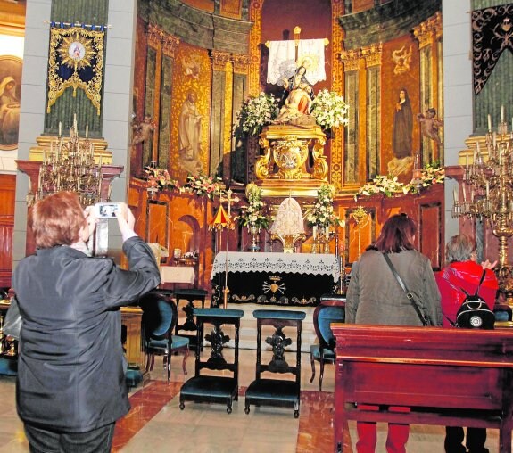 Devotos visitan la iglesia de la Caridad, durante los preparativos en la víspera del día de la Patrona.