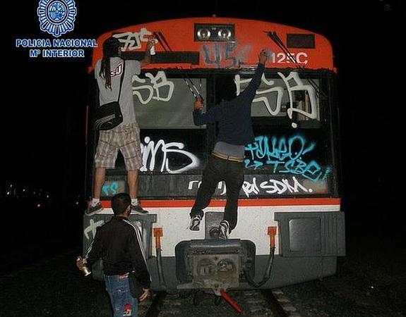 Los detenidos realizan pintadas en un tren. 