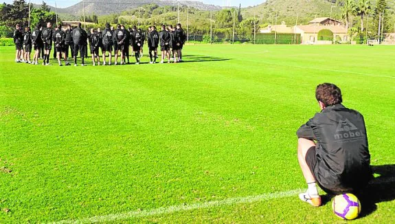 Juan Pablo, sentado en la banda sobre una pelota, observa cómo sus compañeros se entrenan en La Manga Club, en diciembre de 2009. Estaba apartado del grupo. 