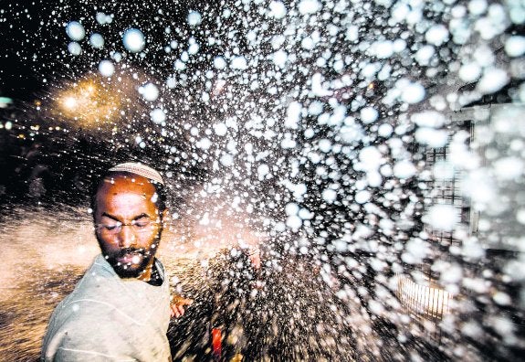 Un judío etíope recibe una descarga de agua de la Policía israelí durante las violentas protestas de estos días en Tel Aviv. 