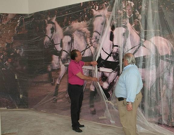 Andrés Espinosa y Pascual Pérez muestran una de las grandes fotografías que ocupan el claustro.