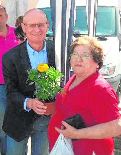 El alcalde, Domingo Coronado, entregando una maceta a una vecina durante un acto de la pasada campaña electoral. 