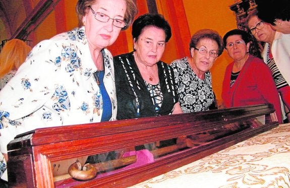 Un grupo de feligresas observa el bastón. 