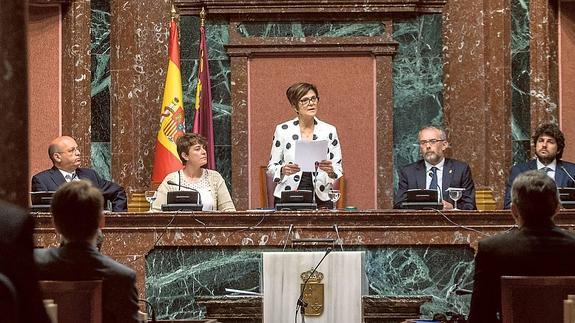 Rosa Peñalver (PSOE) se dirige a la Cámara desde la Mesa, que completan Luis Fernández (C’s), María López (Podemos), Domingo Segado (PP) y López Miras (PP). 