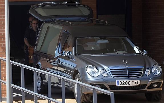 Empleados del tanatorio de El Algar cargan el féretro en el coche fúnebre. 