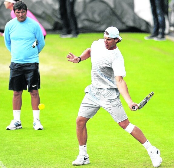 Rafa golpea una pelota ante la atenta mirada de su tío, durante un entrenamiento en Wimbledon.