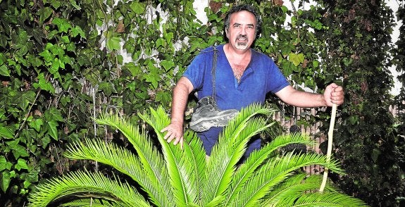 Manuel Moyano con su bastón y sus botas de montaña en el selvático jardín de su casa molinense. 