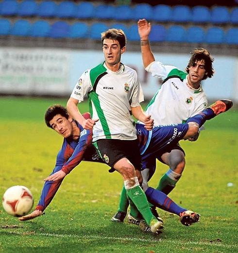 Rivero, en primer plano, disputa un balón en un partido con el Racing de Santander. 