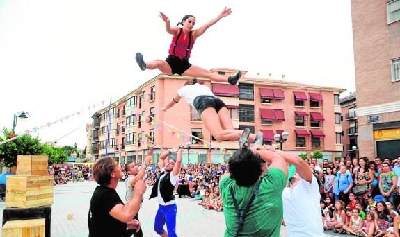 Dos acróbatas realizan un salto, ante la mirada de cientos de espectadores. 