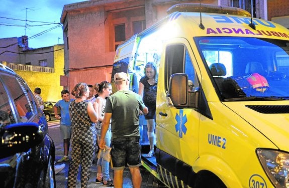 El personal sanitario atiende a uno de los heridos, junto a la ambulancia. 