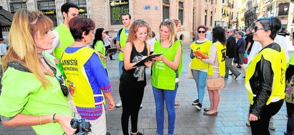 Voluntarios de las ONG recogen firmas, ayer. 