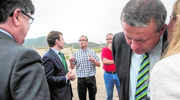 El secretario de Estado de Medio Ambiente, Pablo Saavedra (segundo por la izquierda), escuchando ayer al presidente de la Liga de Vecinos de Portmán, Daniel Portero, durante su visita a la zona. En primer plano, el consejero de Fomento, Francisco Bernabé. 