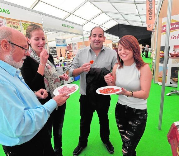 Un grupo de visitantes dando buena cuenta de las degustaciones de embutidos lorquinos. 