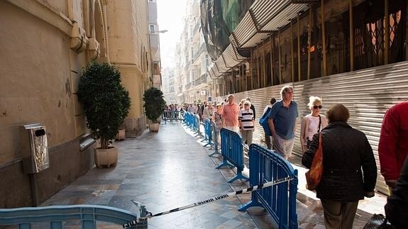 Parte de la calle Mayor acordonada y gente paseando por la zona peatonal junto a la Iglesia Santo Domingo.