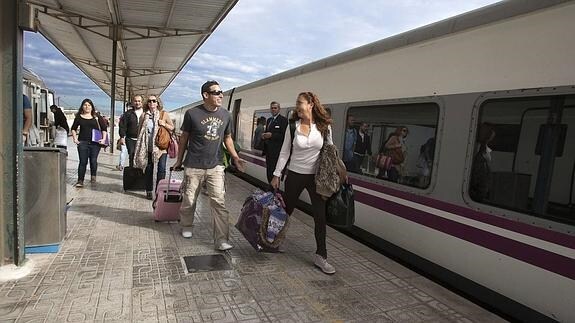 Varios pasajeros se suben a un tren de media distancia en Cartagena. 