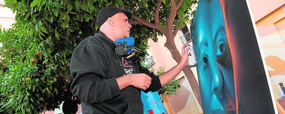 Isaac Garrido, del colectivo Street Museum, pinta un grafiti, durante la presentación de la oficina municipal, ayer en la plaza de Agustinas. 