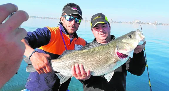 Pascual Valenzuela e Ignacio González posan con la lubina de 6,6 kilos que pescaron en el torneo Barco Amigo.