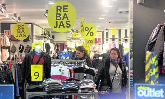 Clientas, en una tienda del centro de Cartagena con carteles anunciadores de rebajas. 