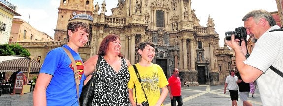 Un grupo de turistas se fotografían en la plaza del Cardenal Belluga, con la Catedral de fondo. 