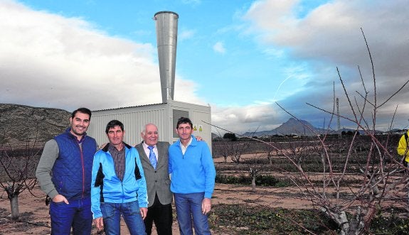 David Ollivier, director de SPAG; Miguel Ángel González, gerente de la SAT Agromergos; Fred Ollivier, presidente de SPAG; y Alfonso González, el otro gerente de la SAT, posando junto a uno de los dos cañones antigranizo instalados en Jumilla. 