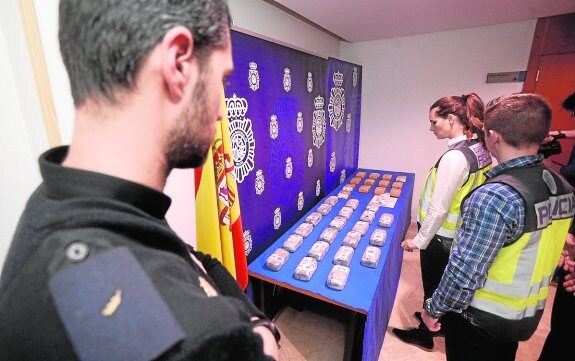 Agentes de la Policía Nacional, junto al alijo de 18 kilos de heroína incautado. 