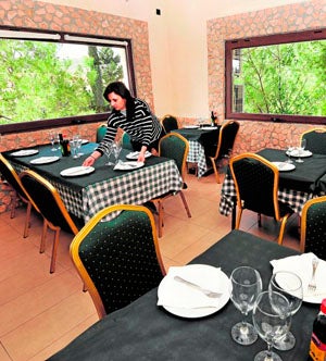 Juana María García prepara una de las mesas de su restaurante.