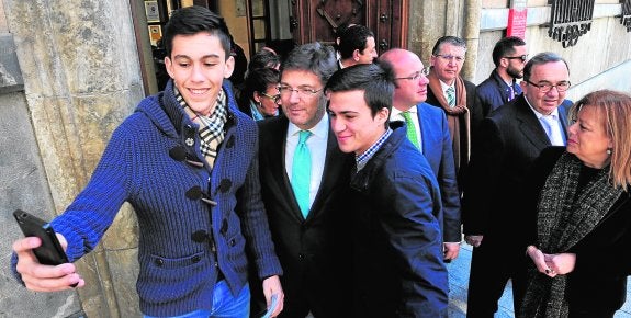 El ministro de Justicia, Rafael Catalá, se hace un selfi junto a dos estudiantes ayer, en la Universidad de Murcia.