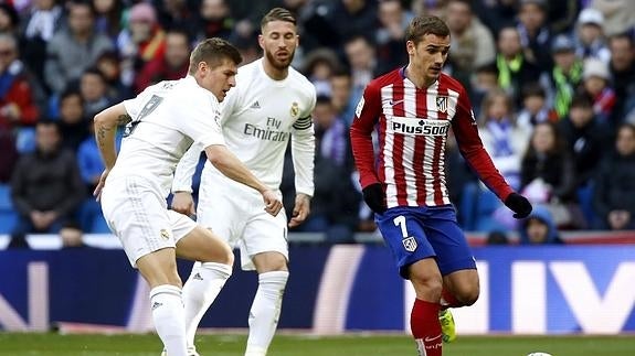 El centrocampista alemán del Real Madrid Toni Kroos pelea un balón con el delantero francés del Atlético de Madrid Antoine Griezmann 