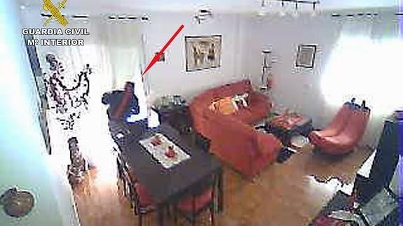 Uno de los asaltantes es grabado por una cámara de seguridad al entrar a una vivienda. 