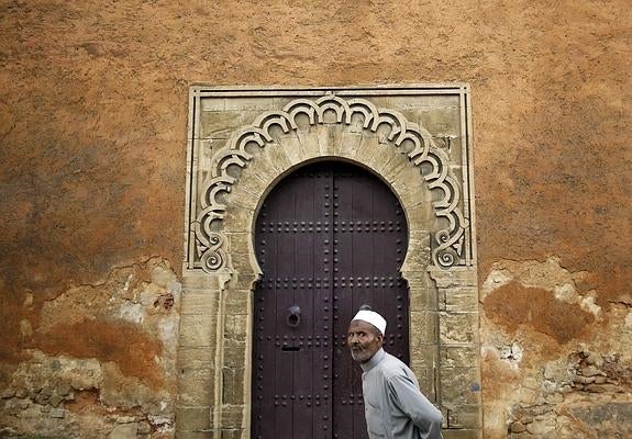 Un hombre pasa por delante de una de las puertas singulares que se pueden encontrar por el barrio de Medina del Rabat (Marruecos). 
