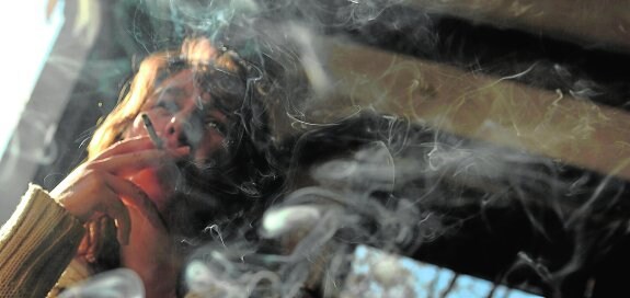 Una mujer fuma en la terraza de un establecimiento. 