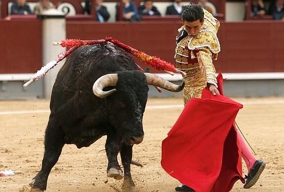 El diestro Alberto Aguilar da un pase con el capote a su primer toro, este domingo en la Monumental de Las Ventas,