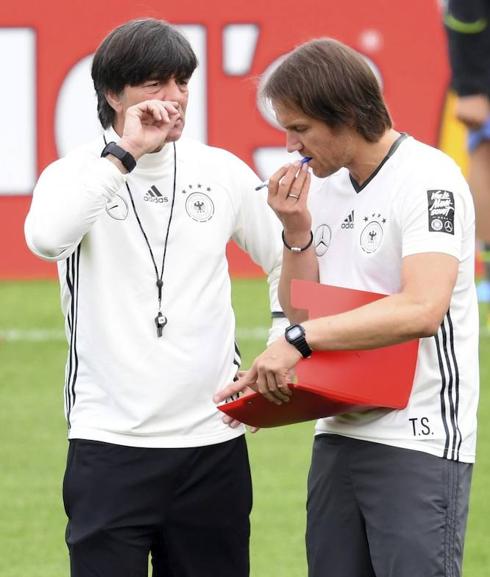 El seleccionador germano, Joachim Löw habla con su asistente Thomas Schneider, en la derecha, en un entrenamiento del equipo en Evian, Francia, para la Eurocopa 2016. 