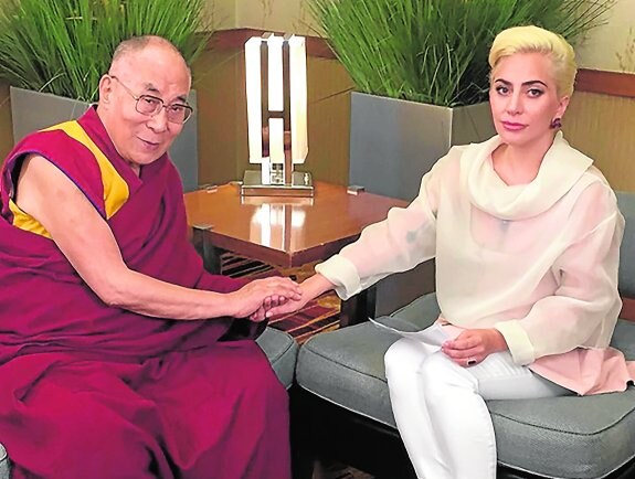 El Dalái Lama estrecha la mano de la artista estadounidense.