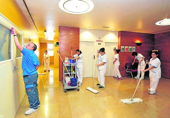 Los 7 discapacitados psíquicos pasan la mopa y limpian ventanas en el edificio Moneo. 