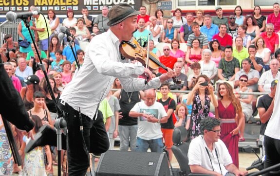 El grupo sueco Räfven, durante su actuación en la Plaza del Ayuntamiento. En la imagen pequeña, una mujer baila con un niño.