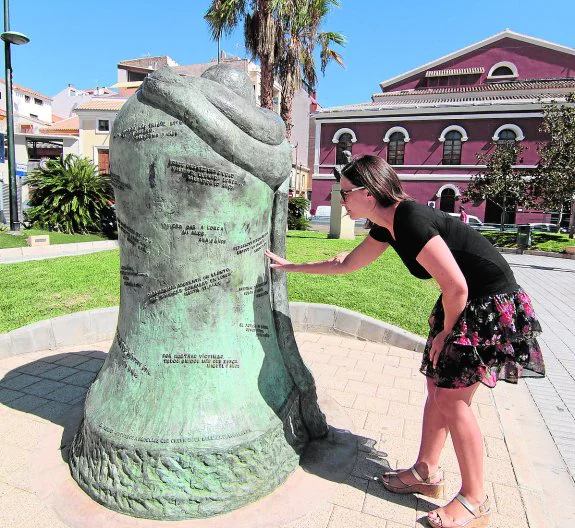 La antropóloga lee, ayer, las inscripciones de la escultura 'Consuelo' que recuerda los seísmos. 