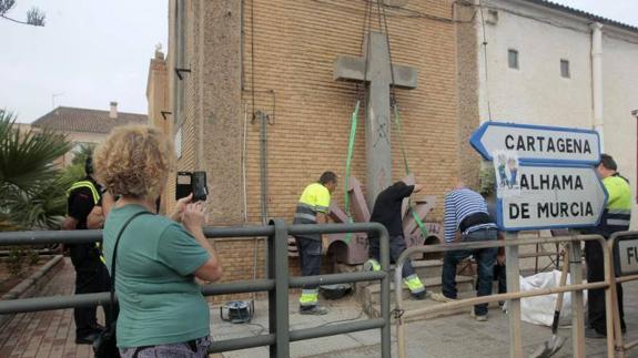 Una vecina fotografía la retirada de los símbolos. 