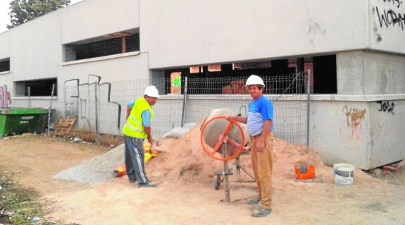 Dos albañiles, ayer, acometiendo las obras de finalización del pabellón del colegio de Las Tejeras.