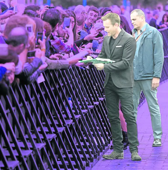El actor Ewan McGregor firma autógrafos ante la vigilante mirada de Carlos Martínez.