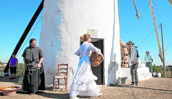 Varios vecinos, con ropas de campo y junto al molino. :: lv
