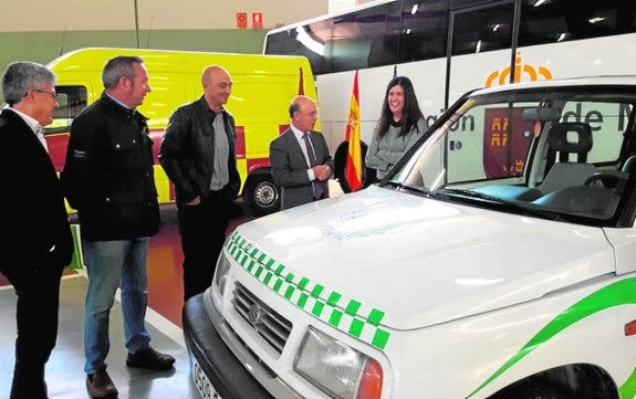El consejero Carrillo (2d), ayer, en el parque móvil durante la entrega de los vehículos a la ONG.