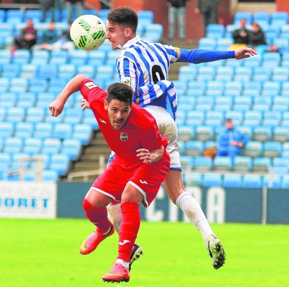 Carlos Martínez lucha con un rival del Recre en el encuentro de ayer.