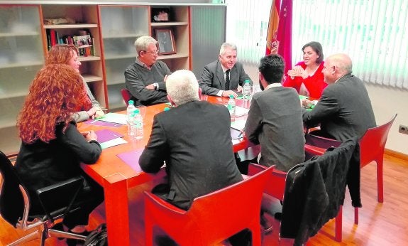 Representantes de Podemos (de espaldas) ayer con Encarna Guillén, Francisco Agulló y otros cargos de la Consejería, en la reunión del Pacto por la Sanidad. 