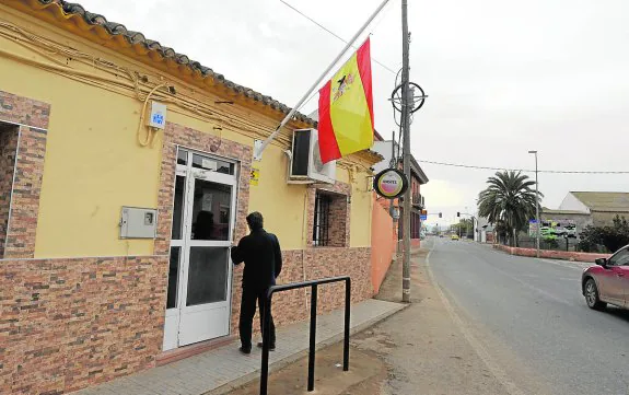Un hombre entra a un bar de La Puebla, en Cartagena, con una bandera a media asta.