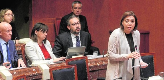 Diputados del PP escuchan, tras perder la votación, a la consejera Encarna Guillén, que intervino al final del Pleno para lamentar el resultado. 