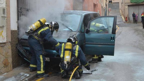 Los bomberos tratan de sofocar el incendio. 