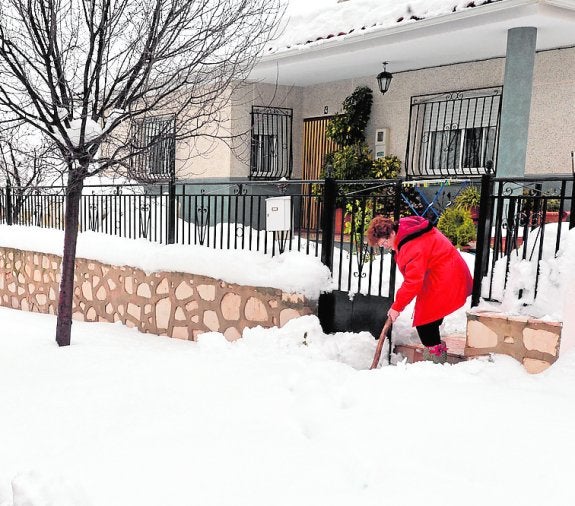 Una vecina retira la nieve en la pedanía lorquina de Coy.