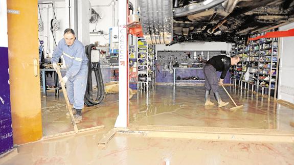 Los trabajadores de un taller de Los Alcázares, sacando lodo el pasado mes de diciembre. 
