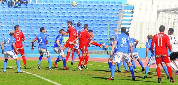 David Sánchez, en el centro de la imagen, remata en una jugada de ataque del Real Murcia en Melilla.